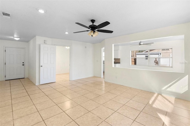 tiled empty room featuring ceiling fan