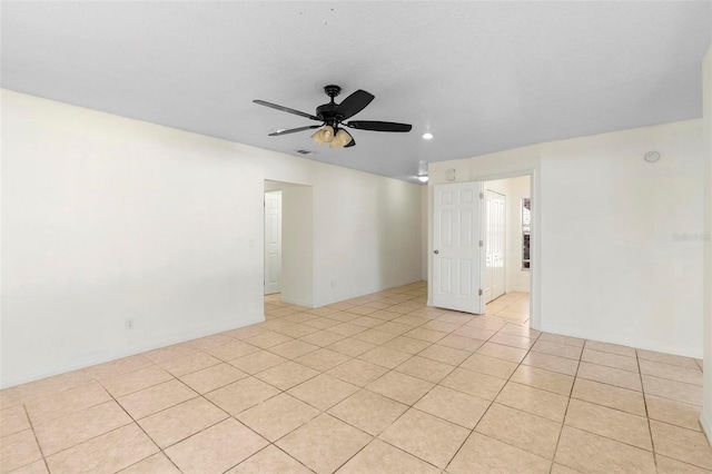 tiled spare room with ceiling fan