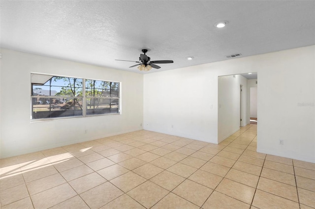 spare room featuring light tile patterned floors, a textured ceiling, and ceiling fan