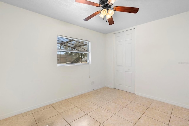 unfurnished room with ceiling fan and light tile patterned flooring