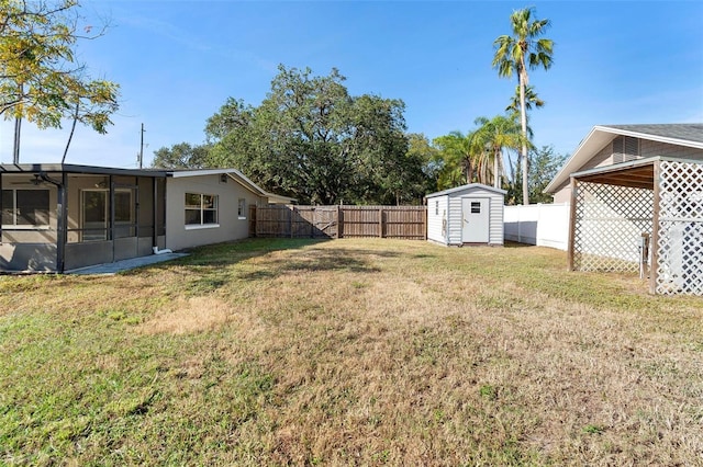 view of yard with a sunroom and a storage unit