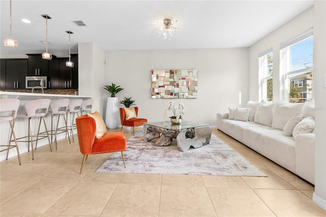 tiled living room featuring an inviting chandelier