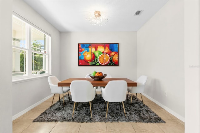 dining space with light tile patterned floors and a notable chandelier