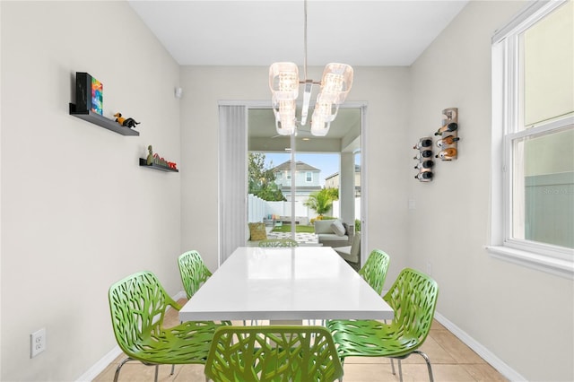 dining room featuring plenty of natural light, light tile patterned floors, and a chandelier