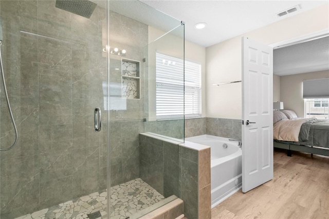 bathroom featuring hardwood / wood-style flooring and plus walk in shower