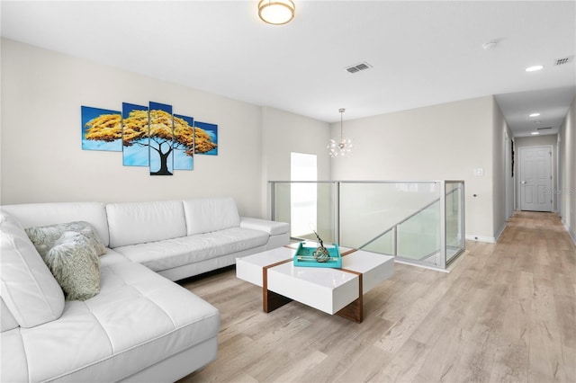 living room featuring a chandelier and light hardwood / wood-style floors