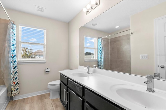 full bathroom featuring vanity, hardwood / wood-style floors, shower / bathtub combination with curtain, and a healthy amount of sunlight