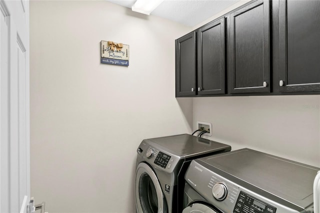 washroom with washer and dryer and cabinets