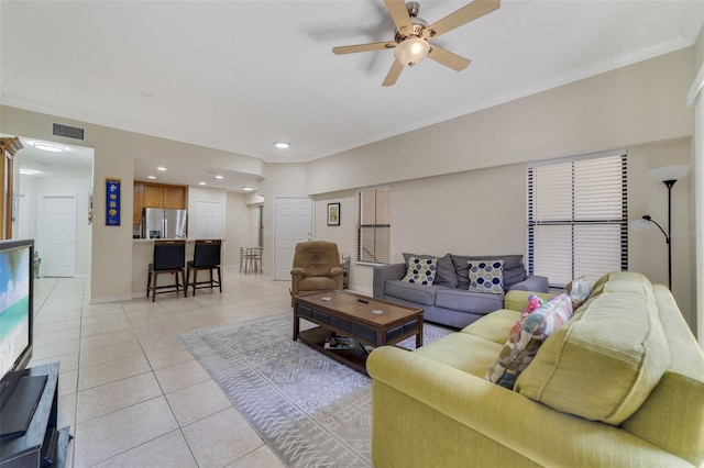 tiled living room featuring ceiling fan and crown molding