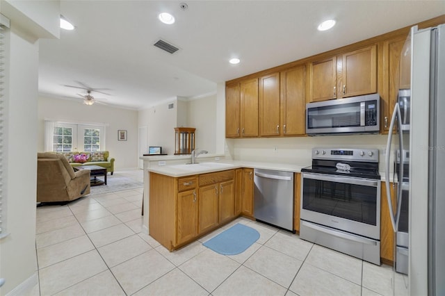 kitchen featuring ceiling fan, sink, kitchen peninsula, crown molding, and appliances with stainless steel finishes