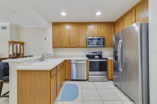 kitchen featuring kitchen peninsula, appliances with stainless steel finishes, a kitchen breakfast bar, crown molding, and sink