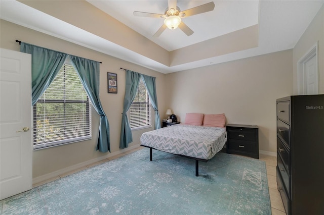 701 Westpark Way Unit 202, Celebration, FL 34747 - bedroom featuring multiple windows, a ceiling fan, light tile patterned flooring, and a tray ceiling