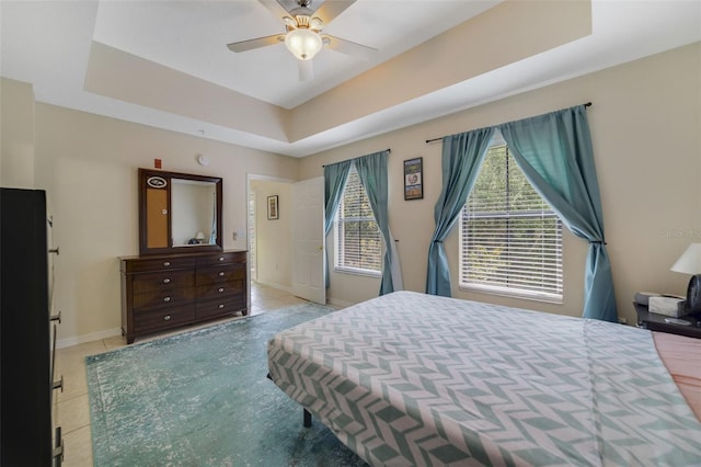 bedroom with a raised ceiling and ceiling fan