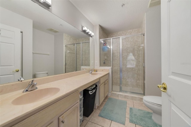 bathroom with tile patterned floors, vanity, toilet, and a textured ceiling