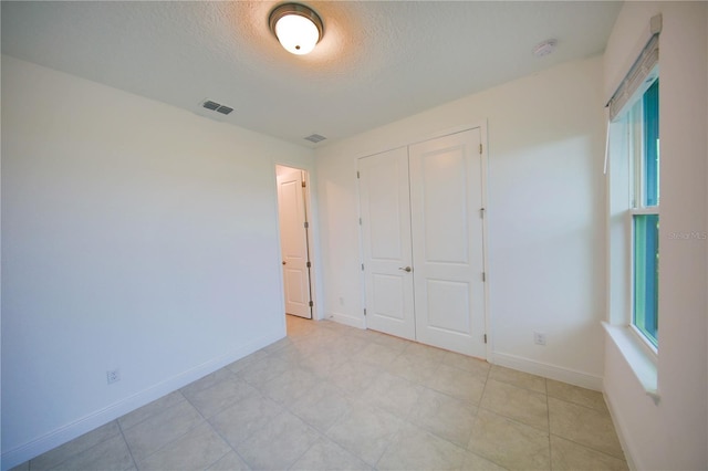 unfurnished bedroom featuring a closet and a textured ceiling