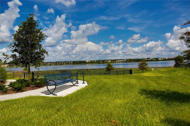 view of home's community with a water view and a lawn