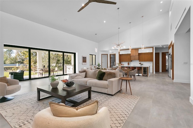 living room with ceiling fan with notable chandelier and a high ceiling