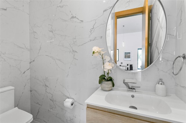 bathroom with toilet, vanity, and tasteful backsplash