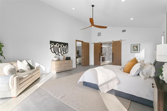 bedroom with ceiling fan, high vaulted ceiling, and a barn door