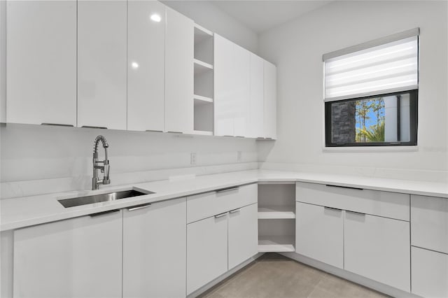 kitchen featuring sink, white cabinets, and light tile patterned flooring