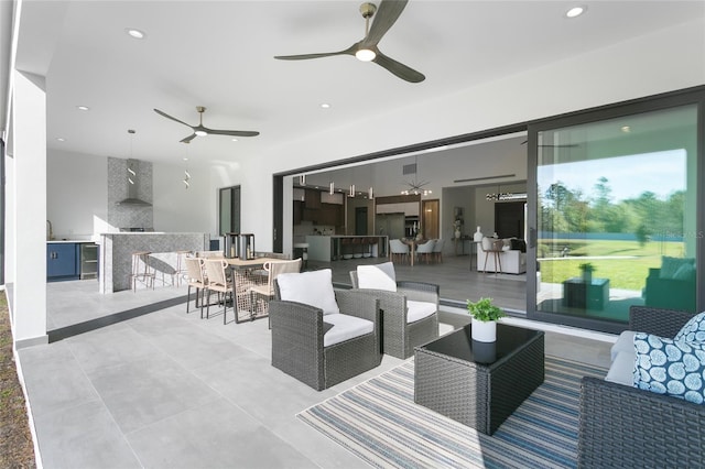 view of patio with ceiling fan, an outdoor living space, and exterior bar