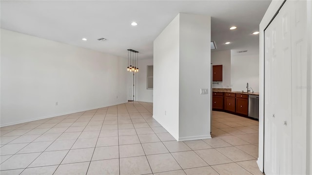 empty room with sink, light tile patterned floors, and a notable chandelier