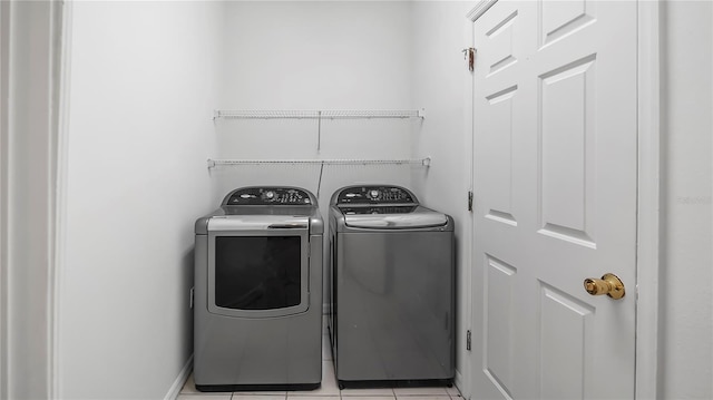 laundry room featuring washing machine and dryer and light tile patterned flooring