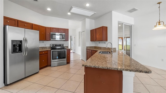 kitchen featuring light tile patterned flooring, appliances with stainless steel finishes, decorative light fixtures, sink, and kitchen peninsula