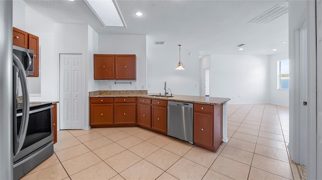 kitchen with sink, appliances with stainless steel finishes, light tile patterned flooring, decorative light fixtures, and kitchen peninsula