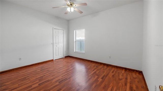 spare room featuring dark wood-type flooring and ceiling fan