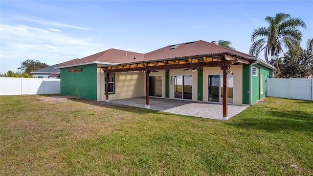 rear view of property with a patio, ceiling fan, and a lawn