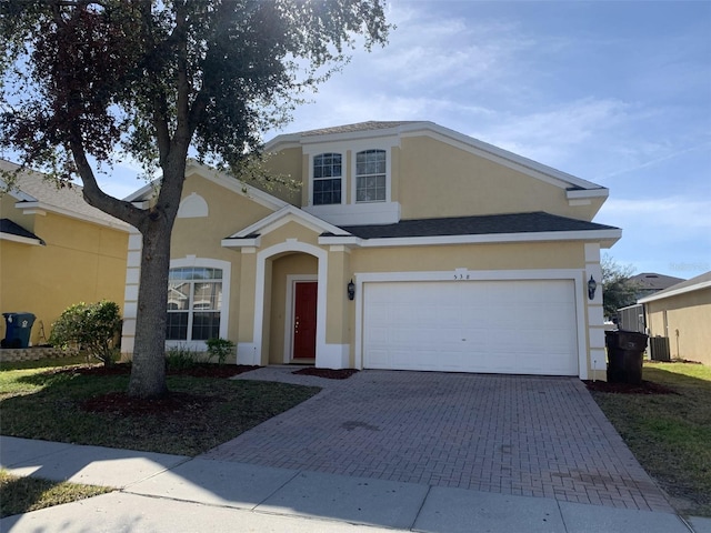 view of front of home featuring central AC and a garage