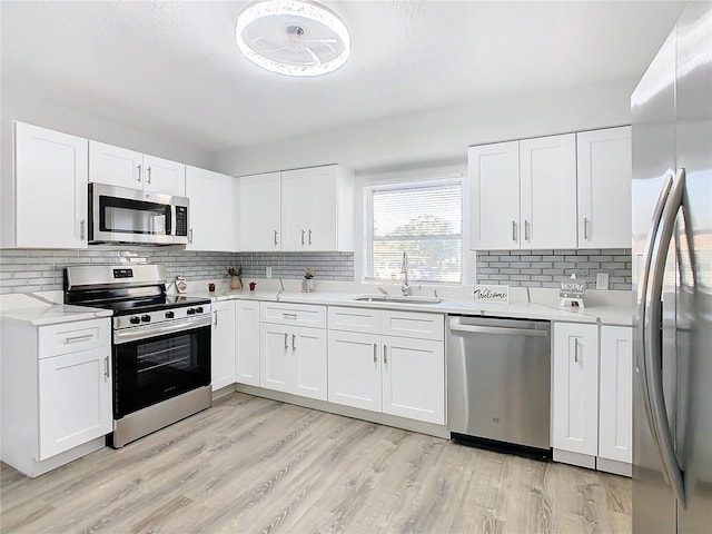 kitchen featuring appliances with stainless steel finishes, sink, and white cabinets