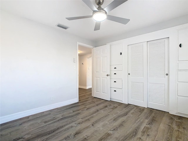 unfurnished bedroom featuring dark hardwood / wood-style flooring, ceiling fan, and a closet