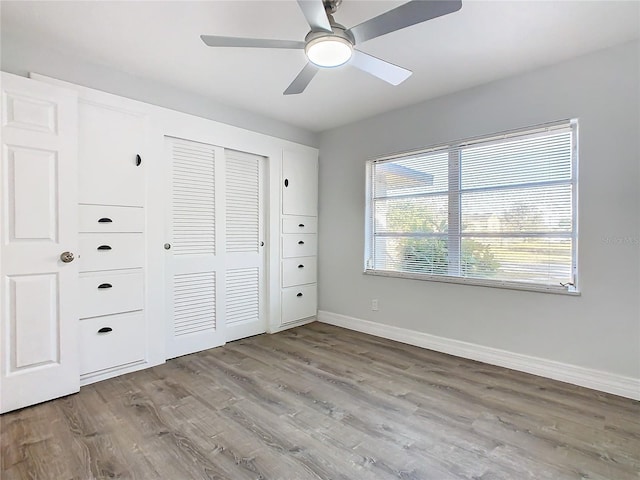 unfurnished bedroom featuring ceiling fan, a closet, and light wood-type flooring