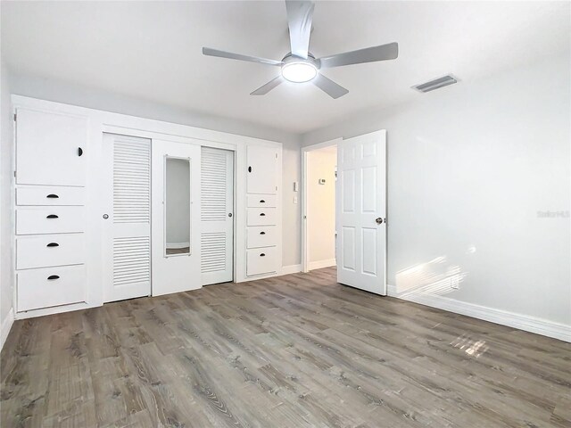 unfurnished bedroom featuring ceiling fan, hardwood / wood-style floors, and a closet