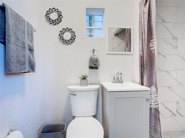 bathroom featuring vanity, toilet, and walk in shower