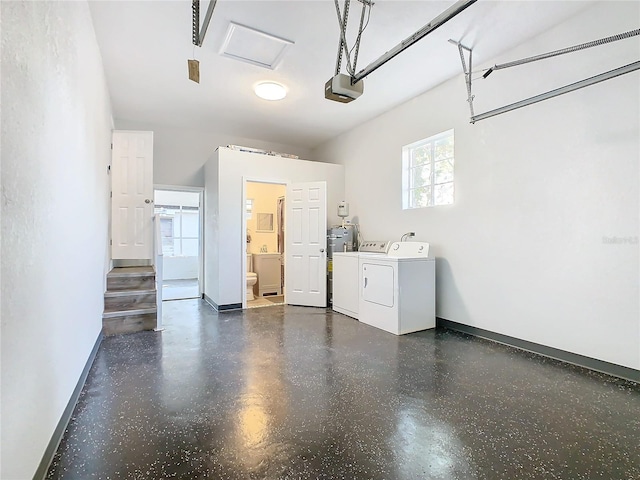 garage with a garage door opener and separate washer and dryer