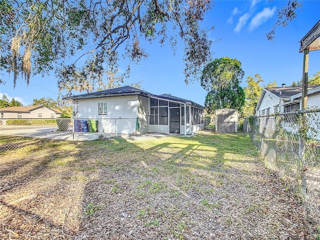 rear view of house with a yard and a storage shed