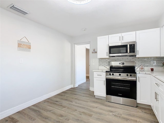 kitchen featuring tasteful backsplash, white cabinetry, appliances with stainless steel finishes, and light hardwood / wood-style floors