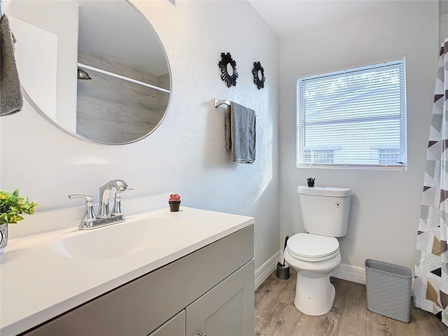 bathroom featuring wood-type flooring, toilet, and vanity