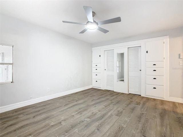 unfurnished bedroom featuring wood-type flooring, ceiling fan, and a closet