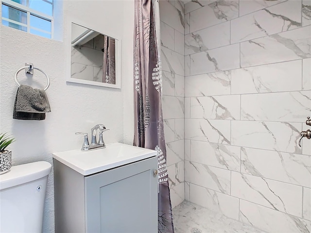 bathroom with walk in shower, vanity, and toilet