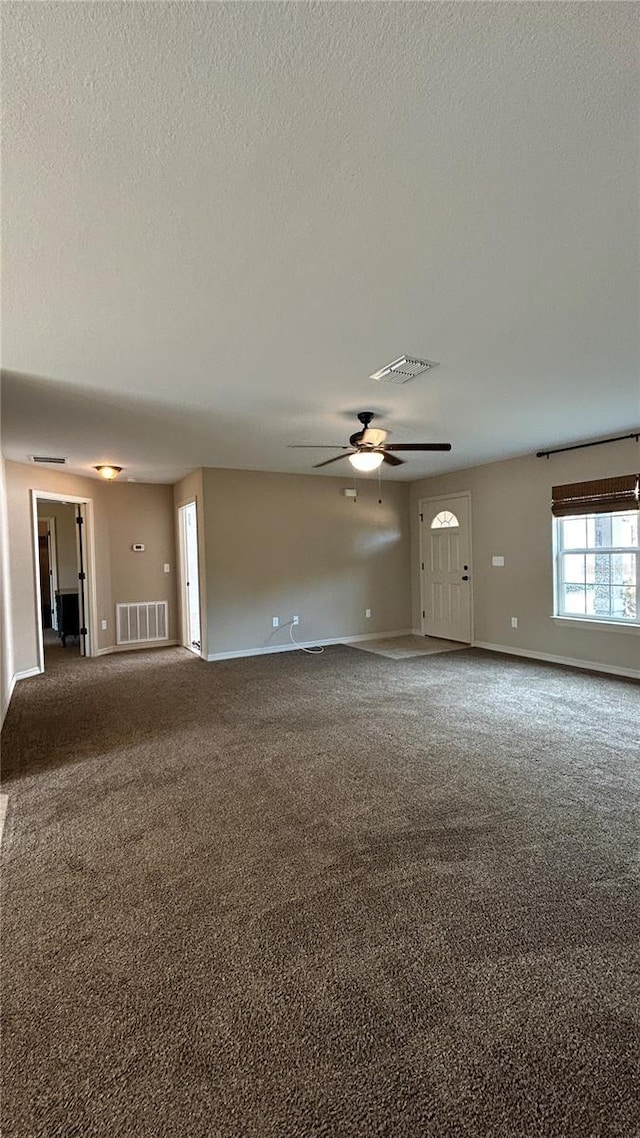 carpeted empty room featuring ceiling fan and a textured ceiling