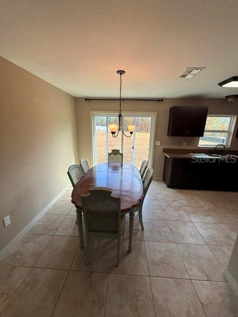 tiled dining area featuring a chandelier