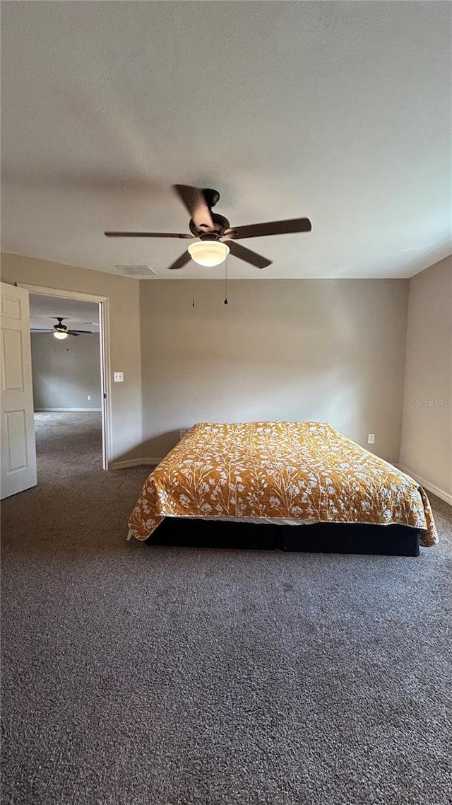 unfurnished bedroom featuring dark colored carpet and ceiling fan