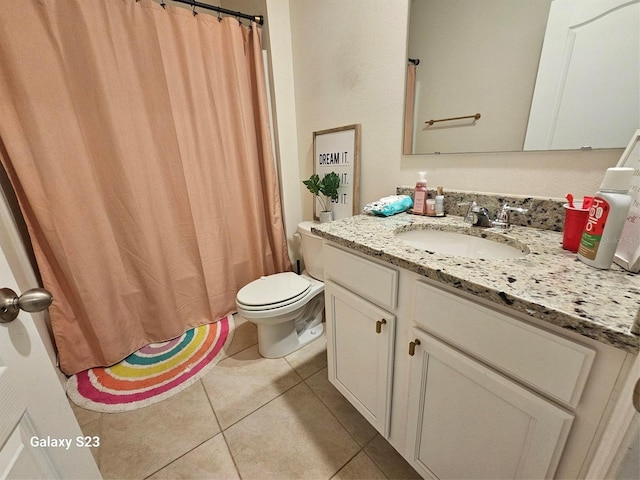 bathroom with tile patterned flooring, vanity, and toilet