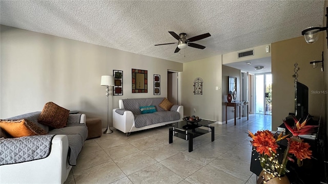 tiled living room with ceiling fan and a textured ceiling