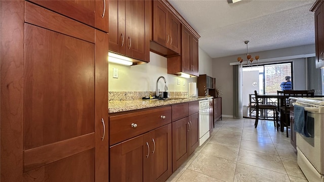 kitchen with light stone countertops, sink, hanging light fixtures, a textured ceiling, and white appliances