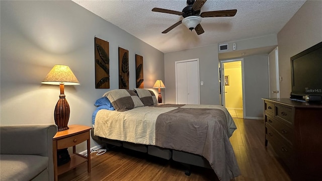 bedroom with hardwood / wood-style floors, ceiling fan, and a textured ceiling